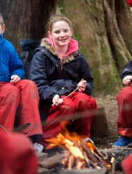 Pupils review learning around a camp fire
