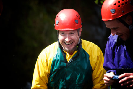 A client laughing with his team during a gorge walk session