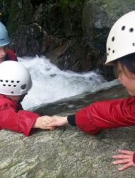 Teamwork in action. Two primary school pupils helping each other in the gorge 